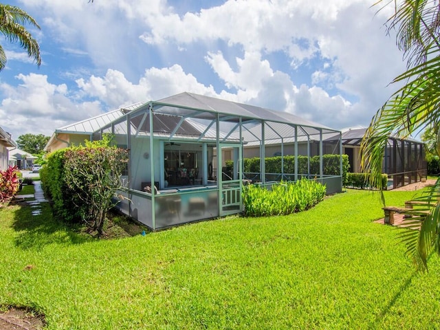 rear view of property featuring glass enclosure and a lawn