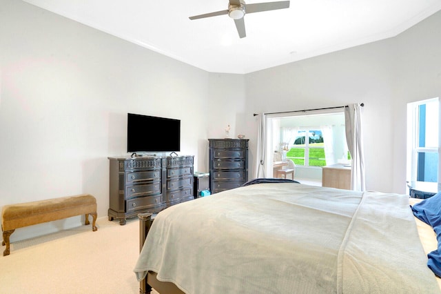 bedroom featuring ornamental molding, light colored carpet, and ceiling fan