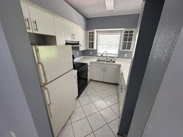 kitchen featuring white refrigerator, black range with electric stovetop, sink, light tile patterned floors, and a textured ceiling