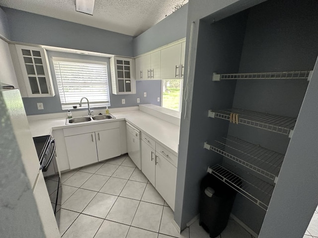 kitchen featuring white cabinets, sink, electric range, a textured ceiling, and light tile patterned flooring