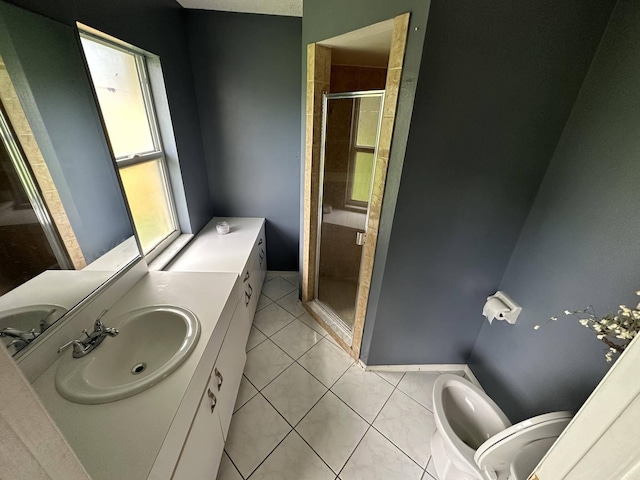 bathroom featuring tile patterned flooring, vanity, toilet, and a shower with door