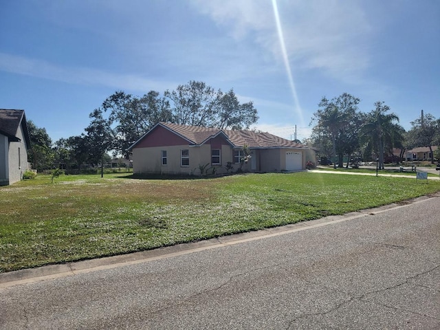 view of side of property with a garage and a lawn