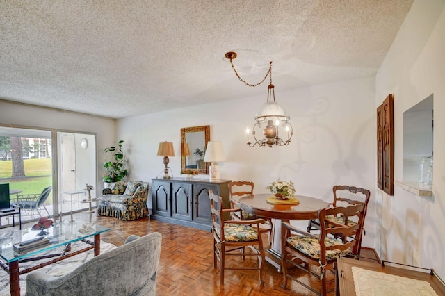 dining area featuring parquet floors, a notable chandelier, and a textured ceiling