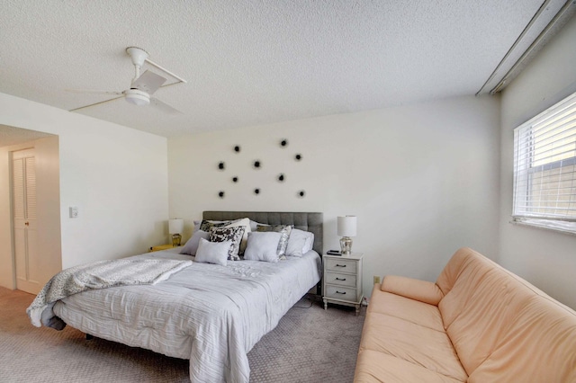 bedroom with carpet, ceiling fan, and a textured ceiling