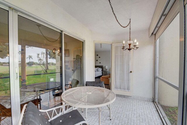 sunroom / solarium with an inviting chandelier