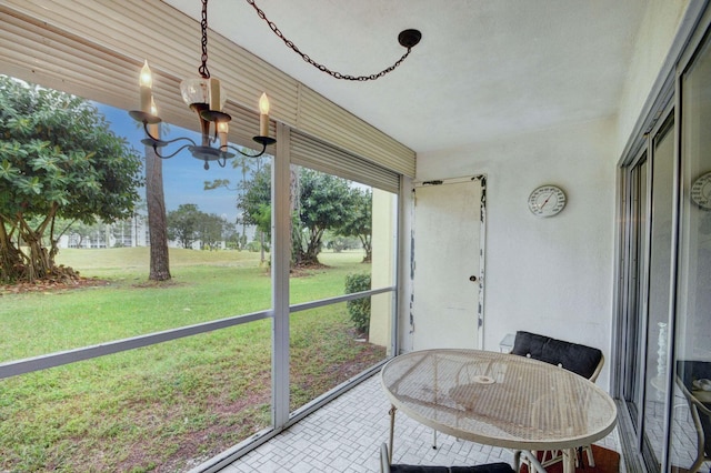 sunroom / solarium with a notable chandelier