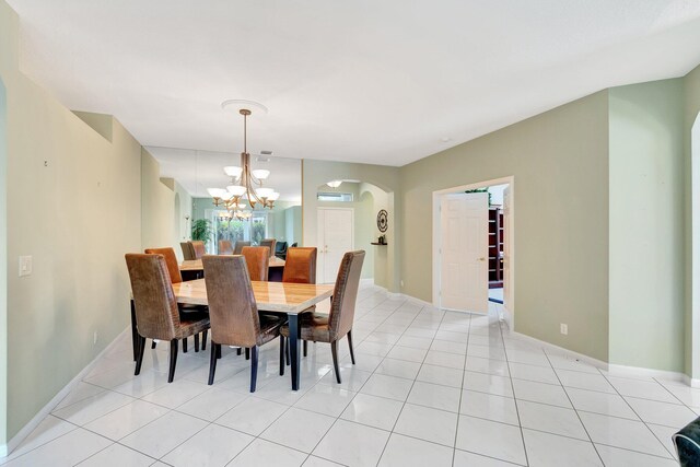 tiled dining area featuring an inviting chandelier