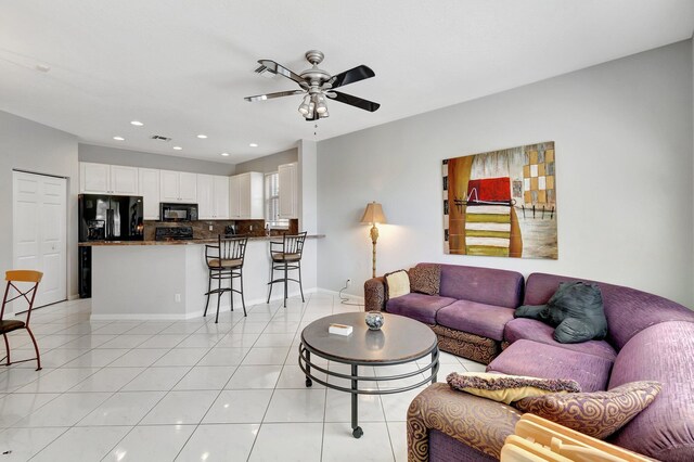 tiled living room with ceiling fan