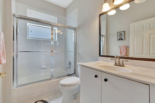 full bathroom featuring tile patterned floors, vanity, toilet, and bath / shower combo with glass door