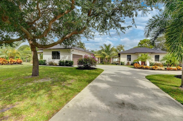 single story home featuring an attached garage, stucco siding, concrete driveway, and a front yard