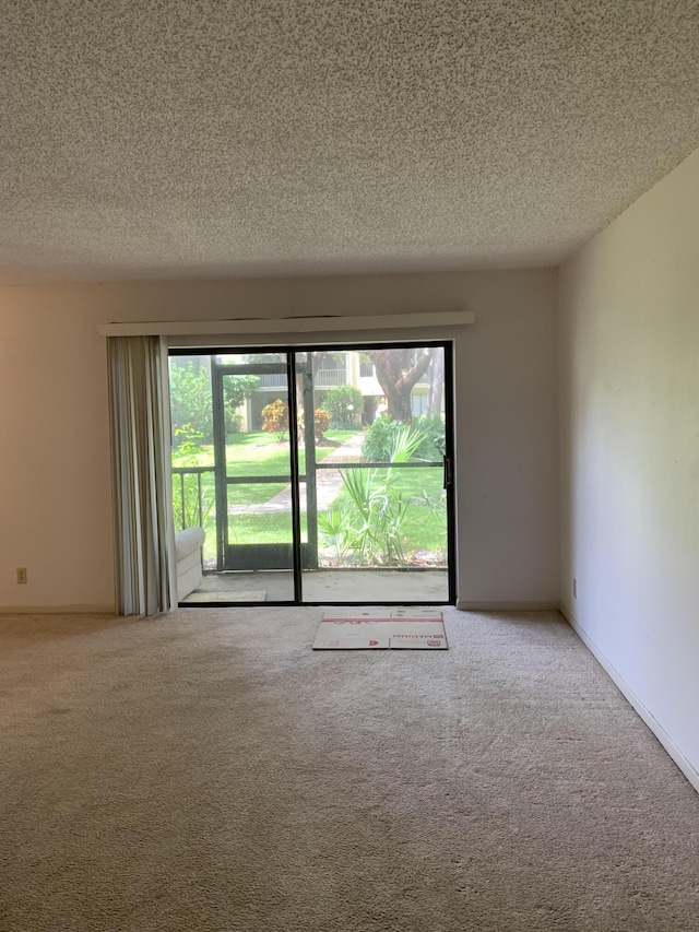 carpeted spare room featuring a textured ceiling