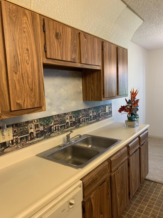 kitchen with sink, white dishwasher, and a textured ceiling