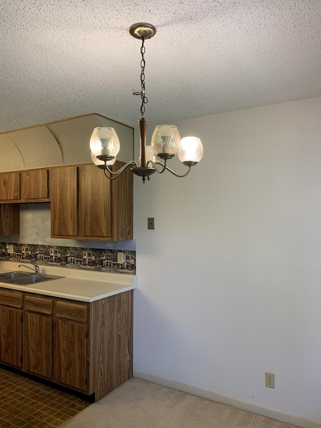 kitchen featuring sink, a textured ceiling, and pendant lighting