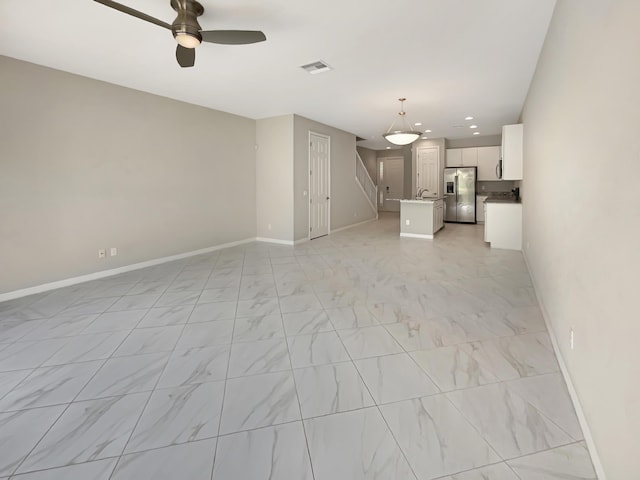 unfurnished living room with ceiling fan