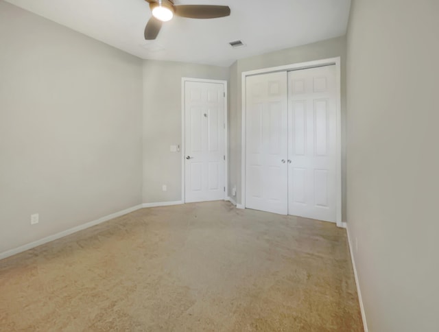 unfurnished bedroom with ceiling fan, light carpet, and a closet