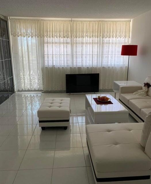 unfurnished living room with a healthy amount of sunlight and light tile patterned floors