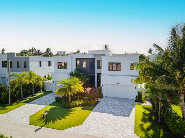 contemporary home with a garage and a front lawn