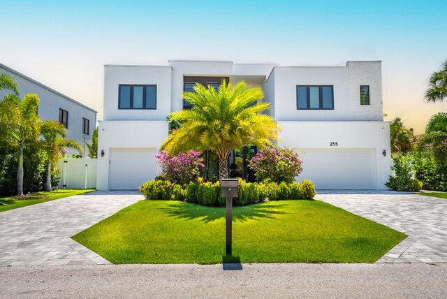 modern home featuring a garage and a front lawn