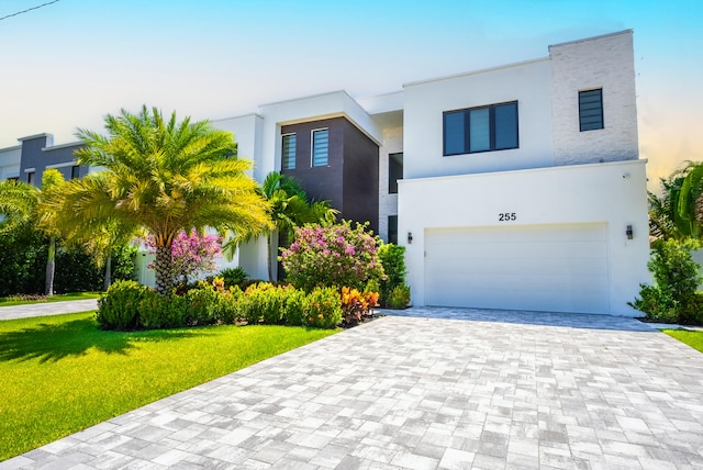 contemporary house featuring a garage and a front lawn