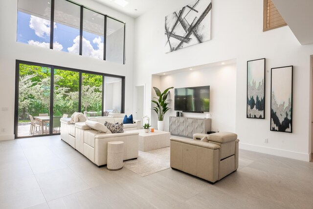 living room with light tile patterned flooring and a towering ceiling