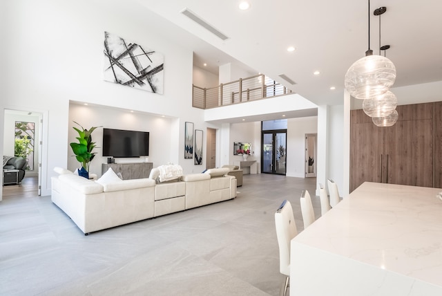 living room featuring a towering ceiling and wooden walls