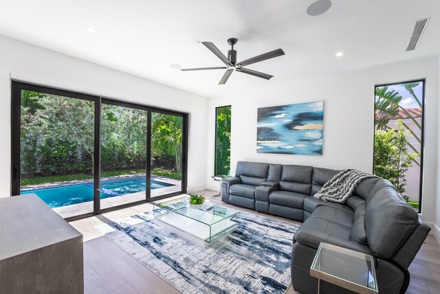 living room featuring wood-type flooring and ceiling fan