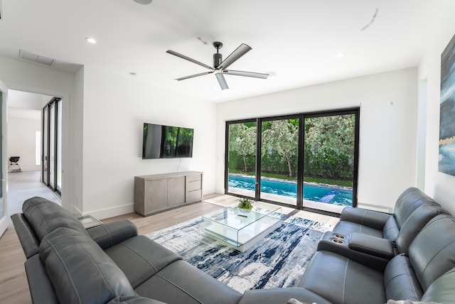 living room featuring light hardwood / wood-style flooring and ceiling fan