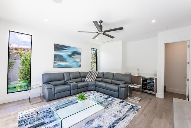 living room featuring beverage cooler, plenty of natural light, and light hardwood / wood-style flooring