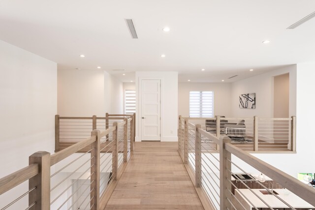 hallway with light hardwood / wood-style floors