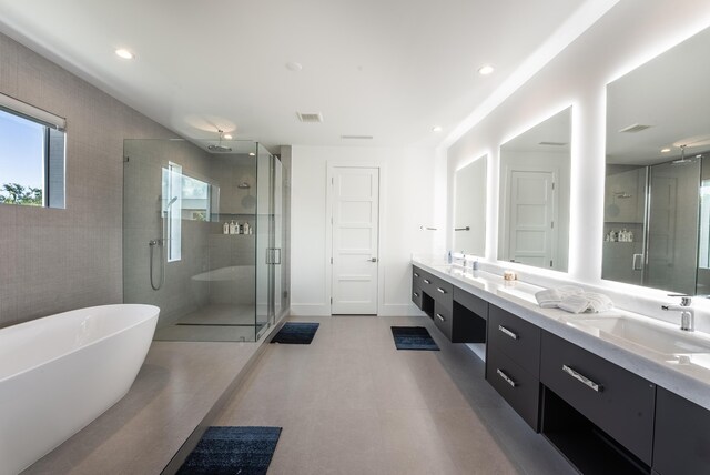 bathroom with vanity and independent shower and bath