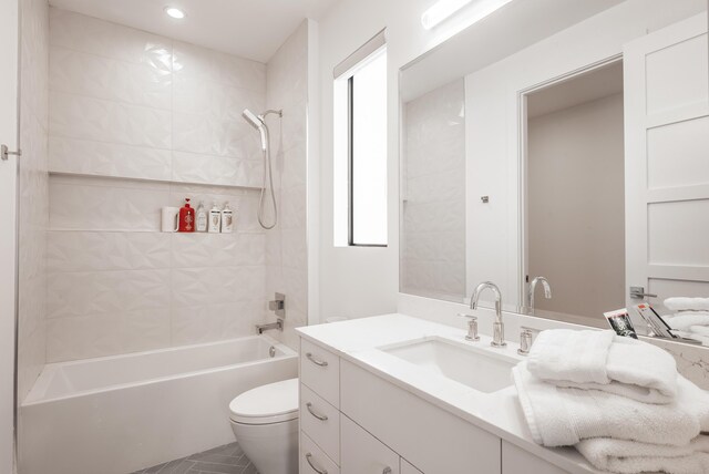 full bathroom featuring tile patterned flooring, toilet, tiled shower / bath combo, and vanity