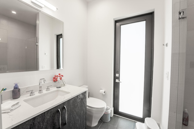 bathroom with a shower, tile patterned flooring, toilet, and vanity