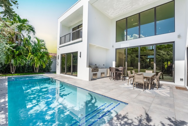 view of pool featuring area for grilling and a patio area