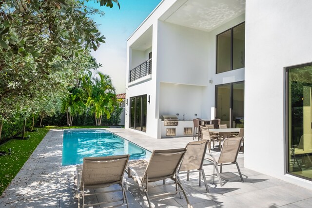 view of pool featuring a grill and a patio area