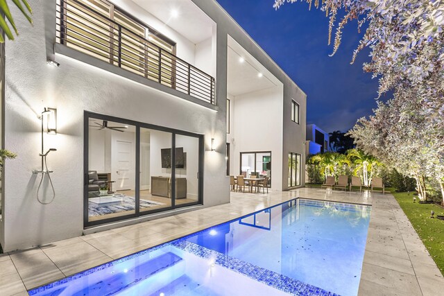 pool at twilight featuring a patio