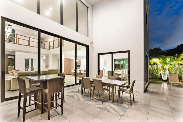 tiled dining space with a towering ceiling