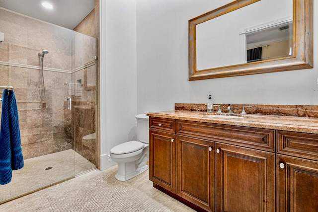 bathroom with tile patterned flooring, vanity, a shower with shower door, and toilet