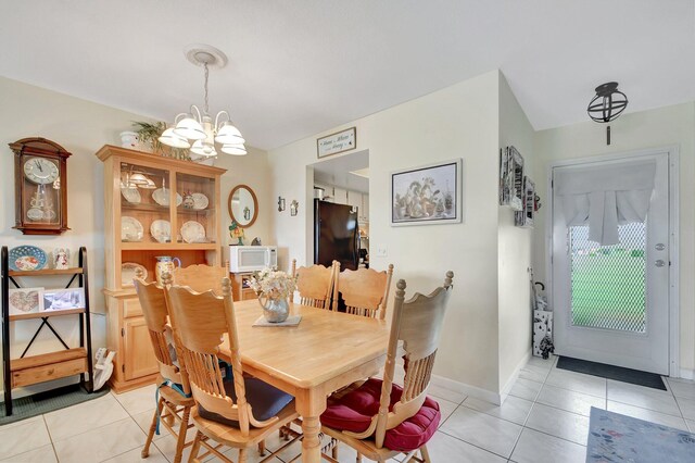 dining area with an inviting chandelier and light tile patterned flooring