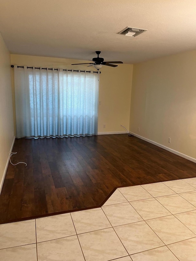 unfurnished room with ceiling fan, light hardwood / wood-style floors, and a textured ceiling