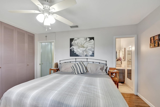 bedroom with ceiling fan, connected bathroom, and light hardwood / wood-style flooring