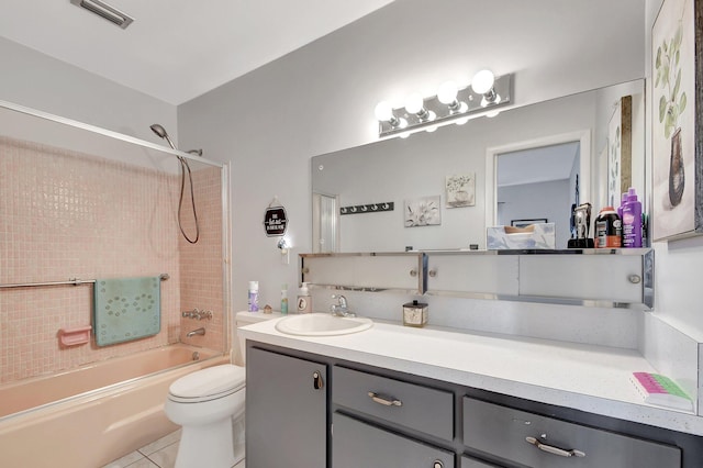 full bathroom featuring toilet, vanity, tiled shower / bath, and tile patterned flooring