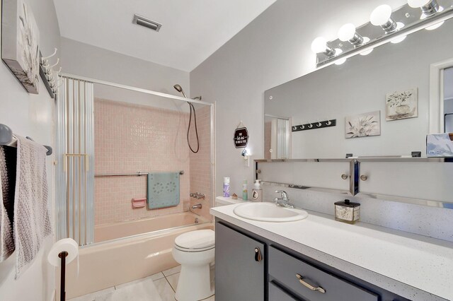 full bathroom with toilet, tile patterned floors, tiled shower / bath, and vanity