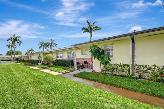 single story home featuring a front lawn