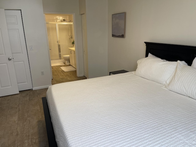 bedroom with hardwood / wood-style flooring and ensuite bathroom