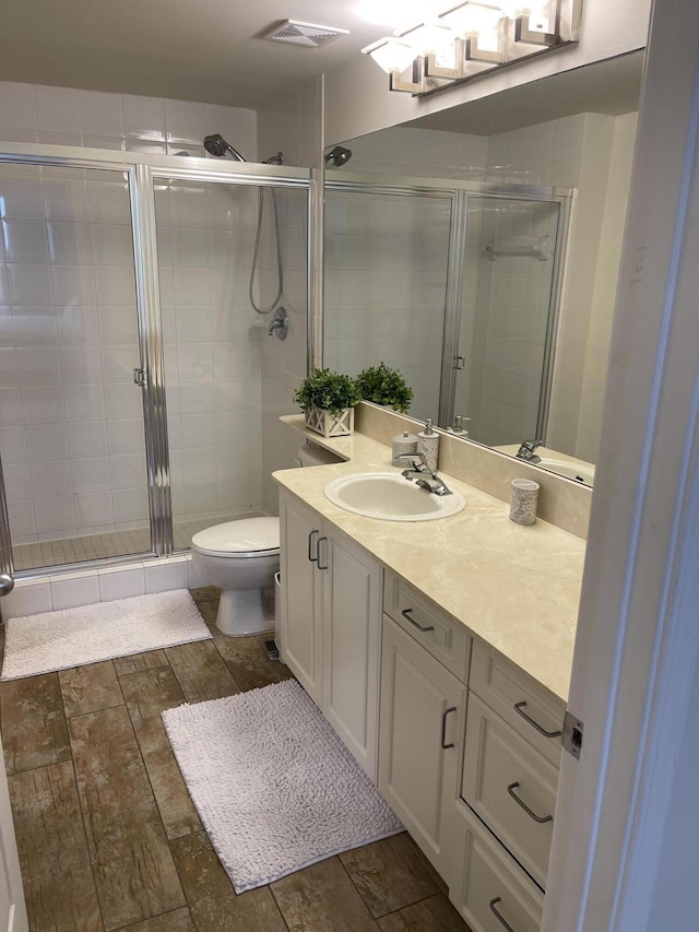 bathroom featuring walk in shower, vanity, and toilet