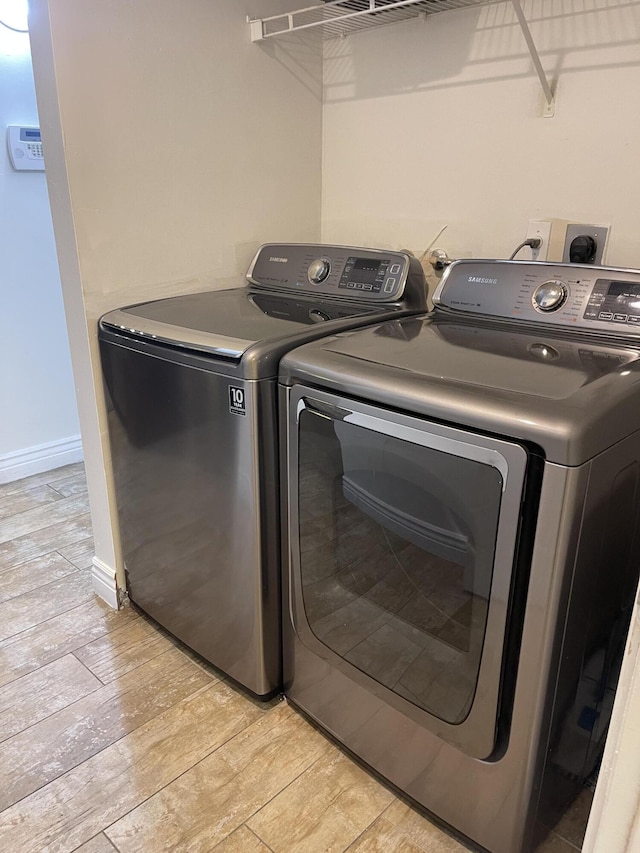 washroom with separate washer and dryer and light hardwood / wood-style flooring