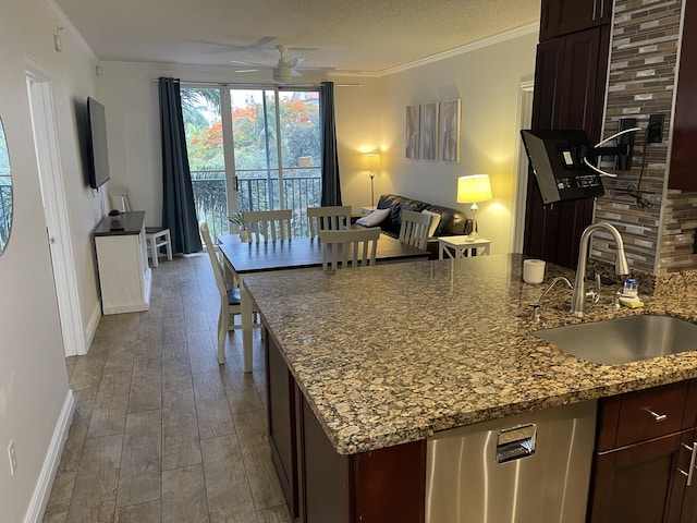 kitchen featuring stainless steel dishwasher, ornamental molding, sink, and wood-type flooring