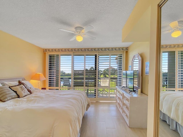 bedroom with access to exterior, a textured ceiling, and ceiling fan