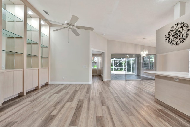 unfurnished living room featuring ceiling fan with notable chandelier, light wood-type flooring, and lofted ceiling