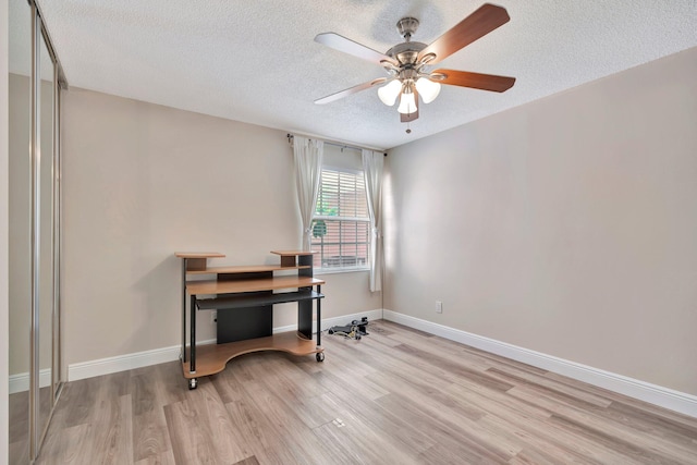 office with ceiling fan, light hardwood / wood-style floors, and a textured ceiling